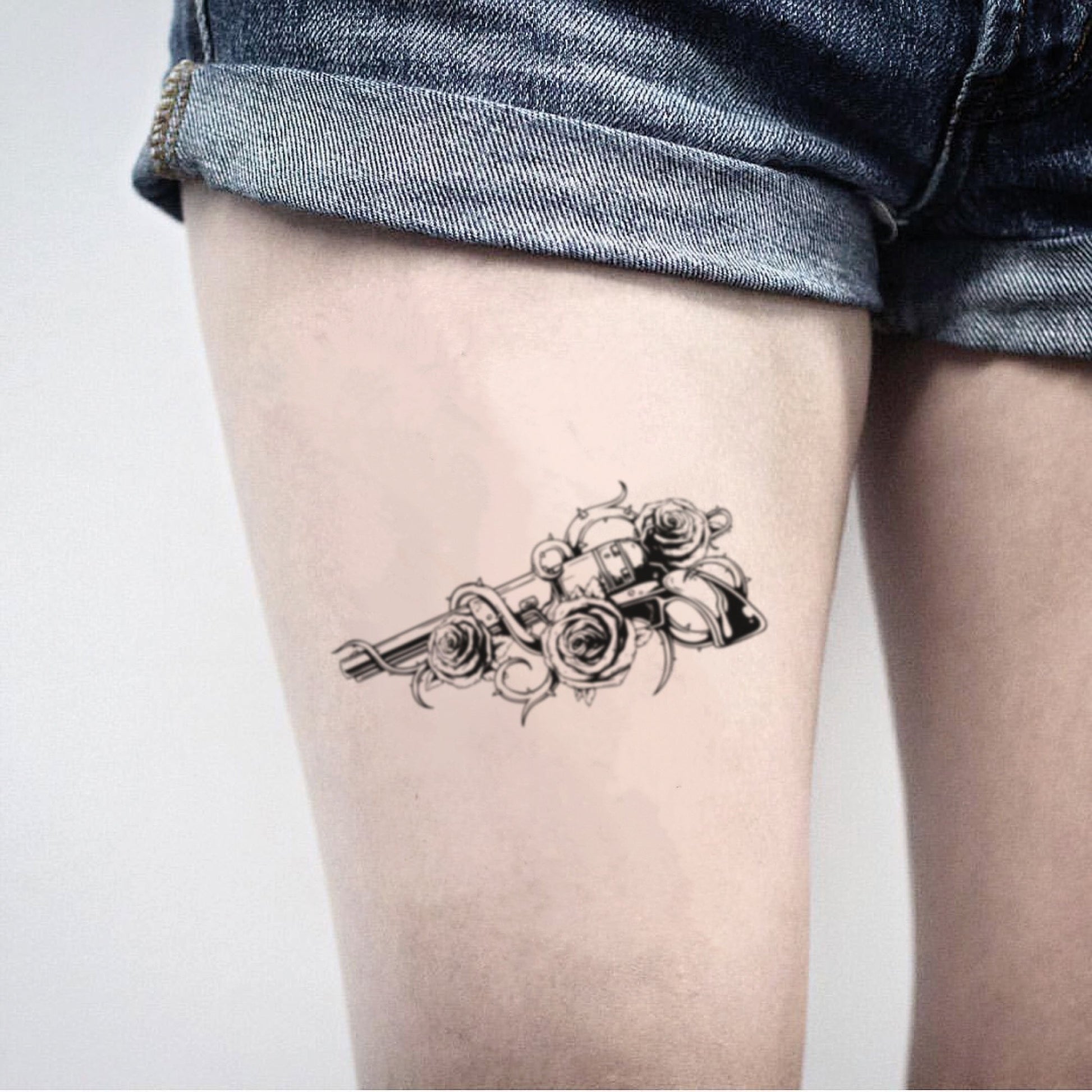 fake big gun and roses illustrative temporary tattoo sticker design idea on thigh