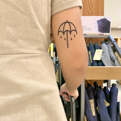 fake small black raining umbrella illustrative tricep temporary tattoo sticker design idea on upper arm elbow