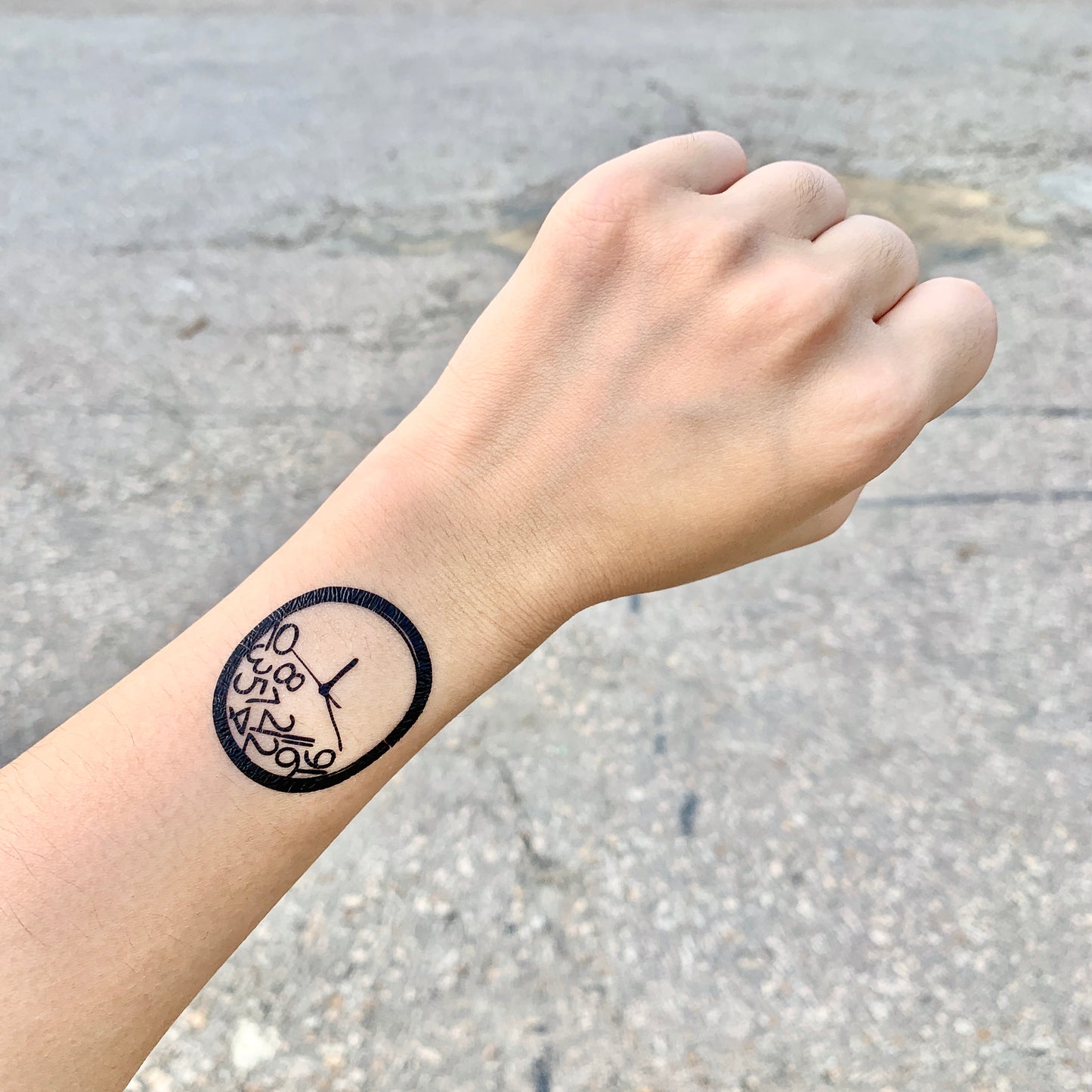 fake small broken clock face illustrative temporary tattoo sticker design idea on wrist