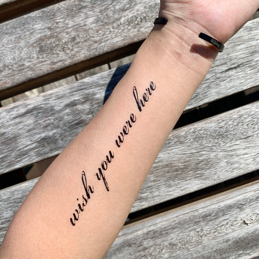 fake medium wish you were here lettering temporary tattoo sticker design idea on forearm