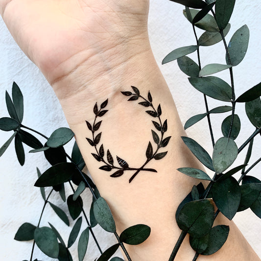 fake small laurel wreath minimalist temporary tattoo sticker design idea on wrist