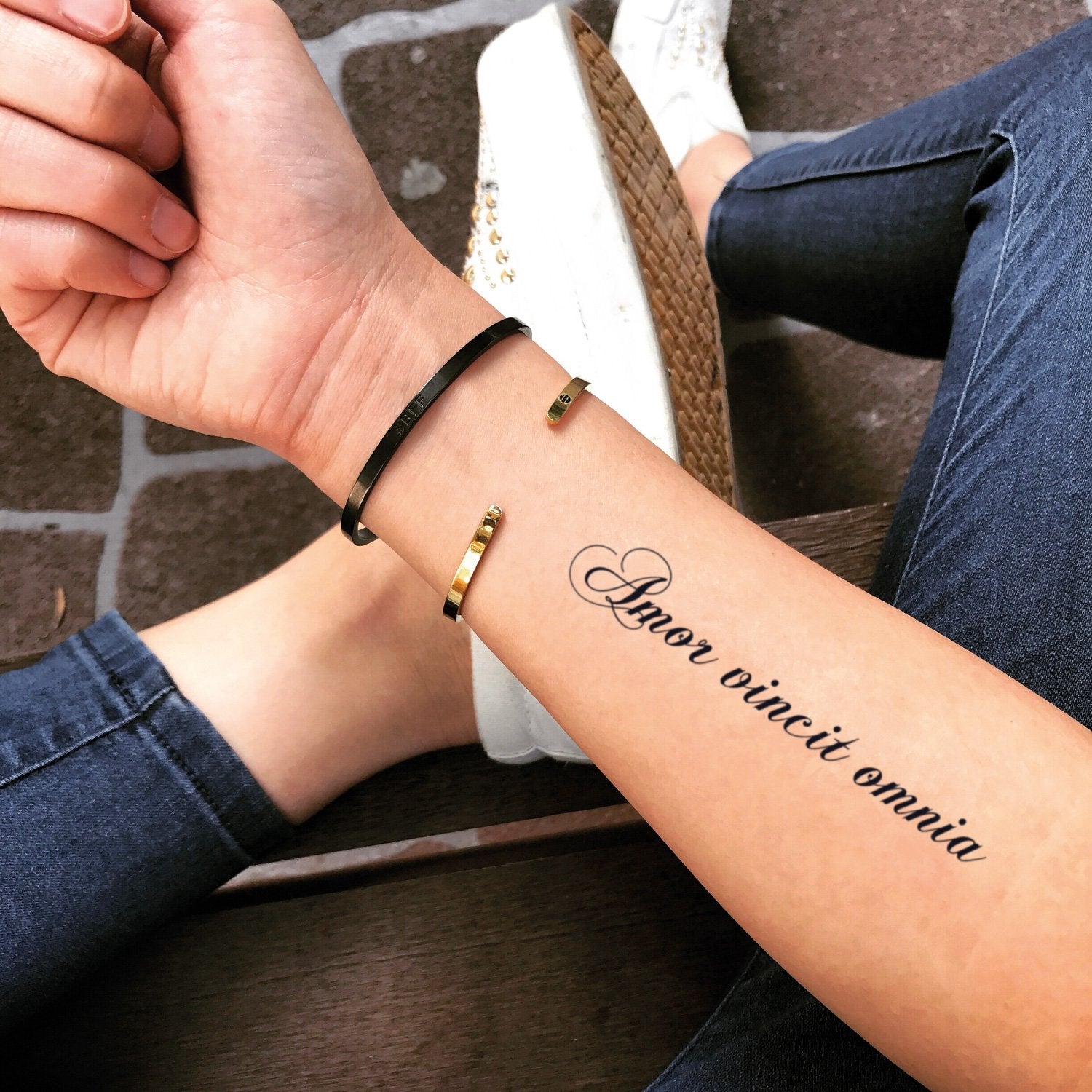 fake medium love conquers all lettering temporary tattoo sticker design idea on forearm