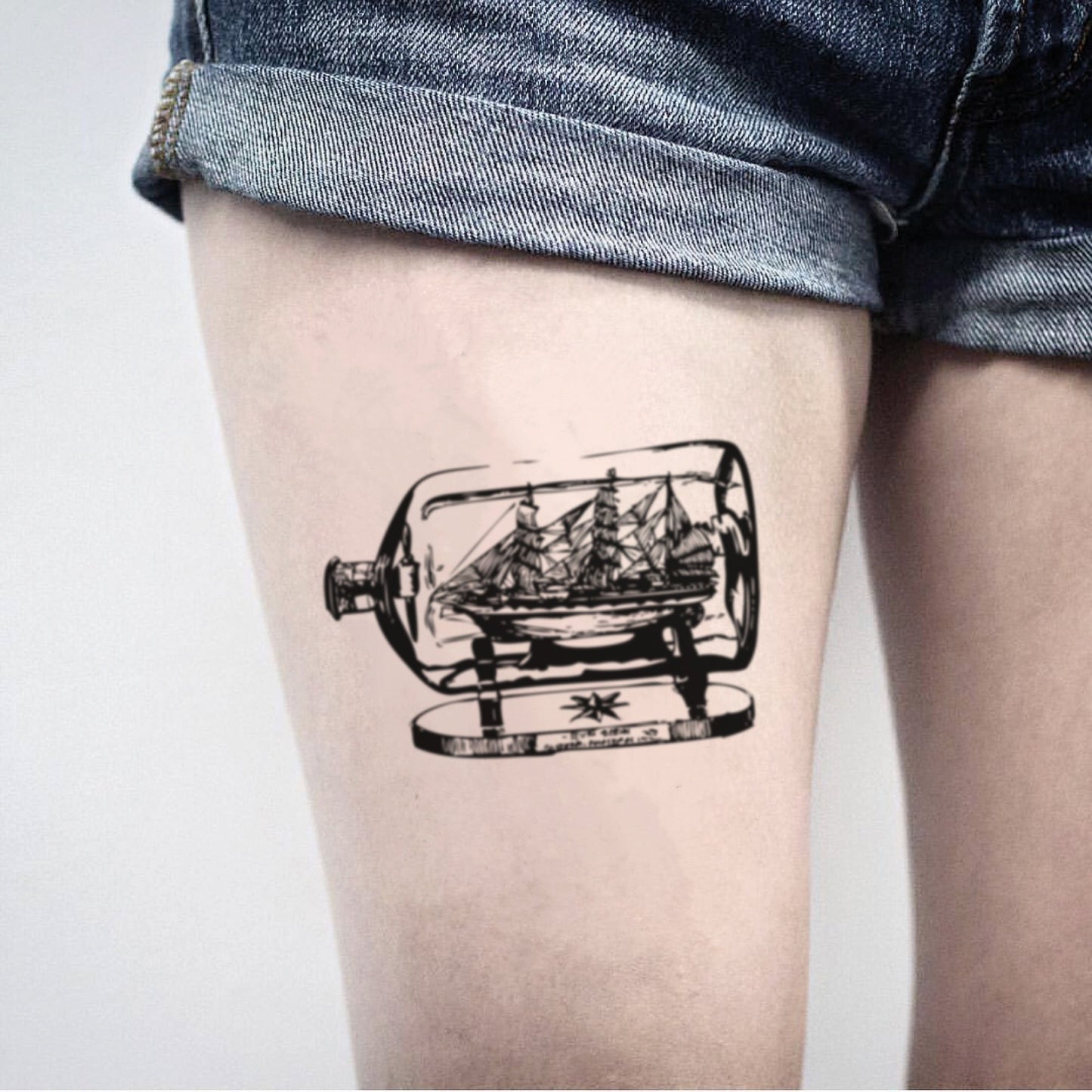 fake medium ship in a bottle vintage temporary tattoo sticker design idea on thigh
