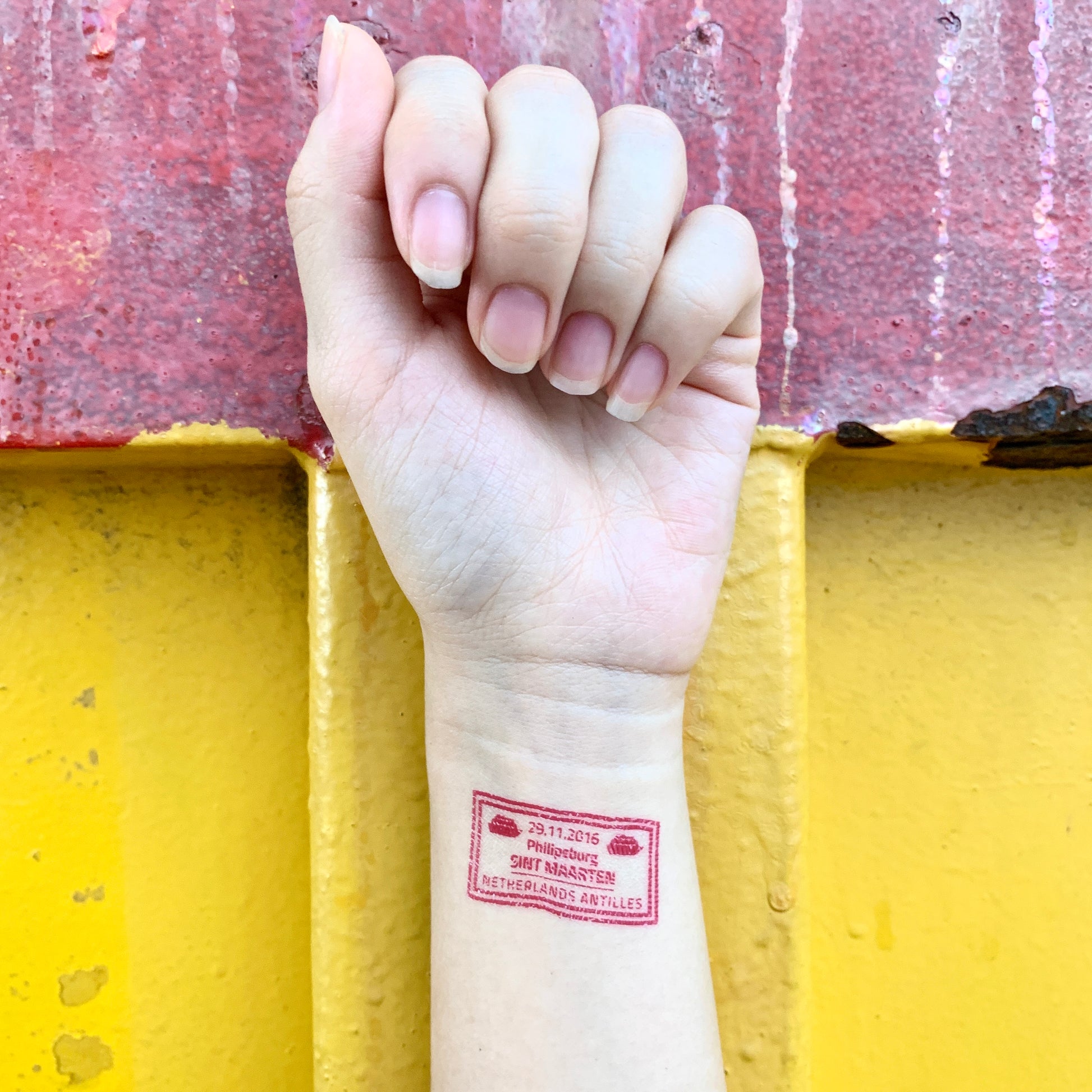 fake small passport stamp color temporary tattoo sticker design idea on wrist