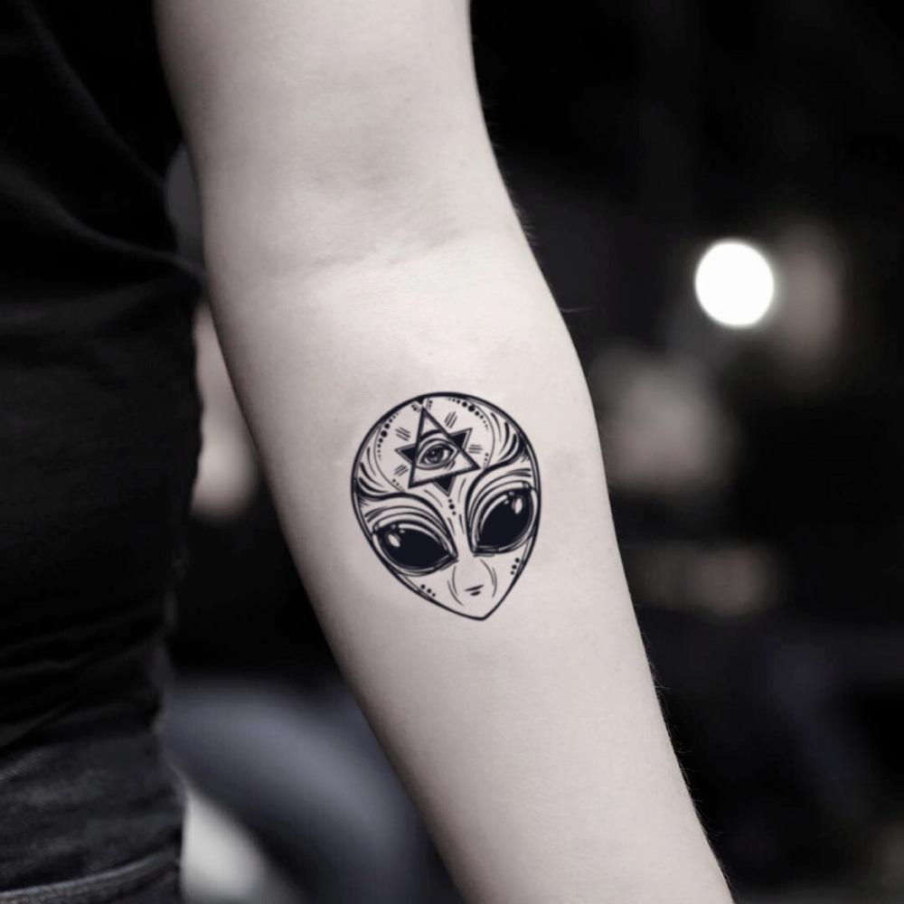 fake small alien head illustrative temporary tattoo sticker design idea on inner arm