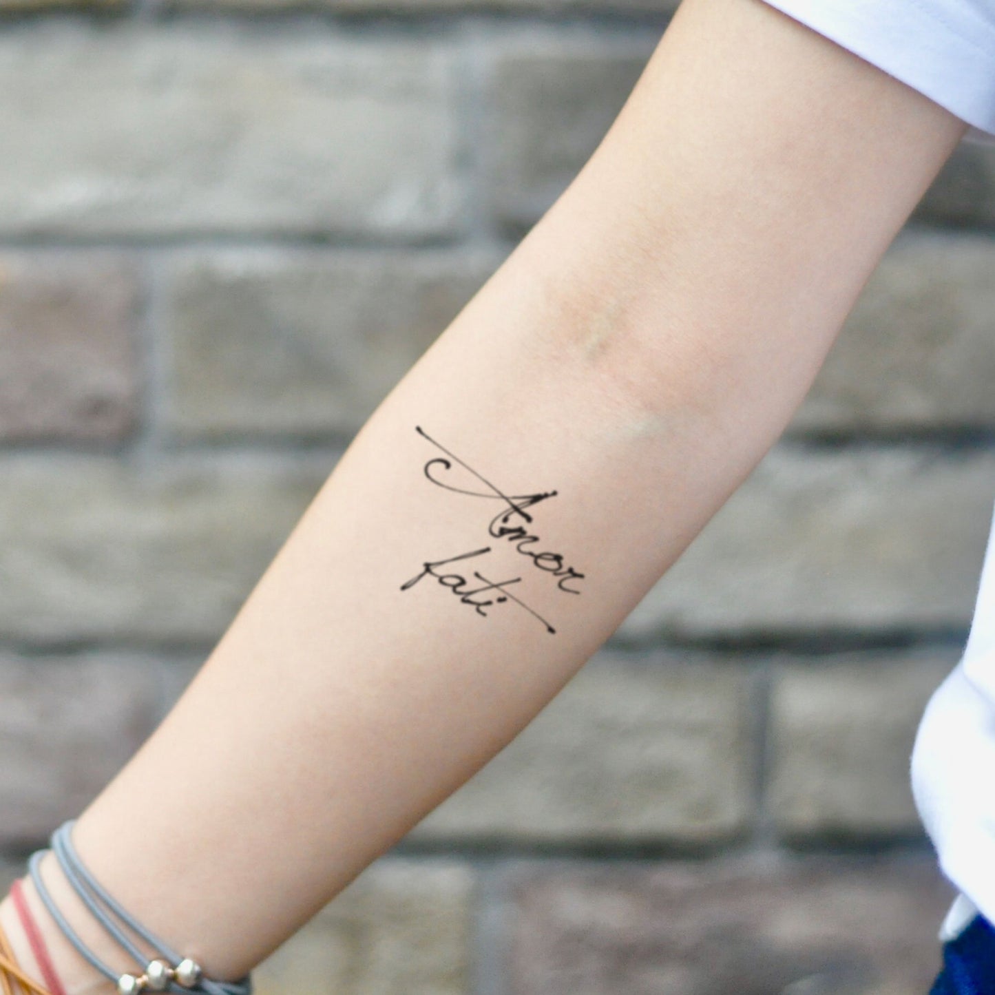 fake small amor fati lettering temporary tattoo sticker design idea on inner arm