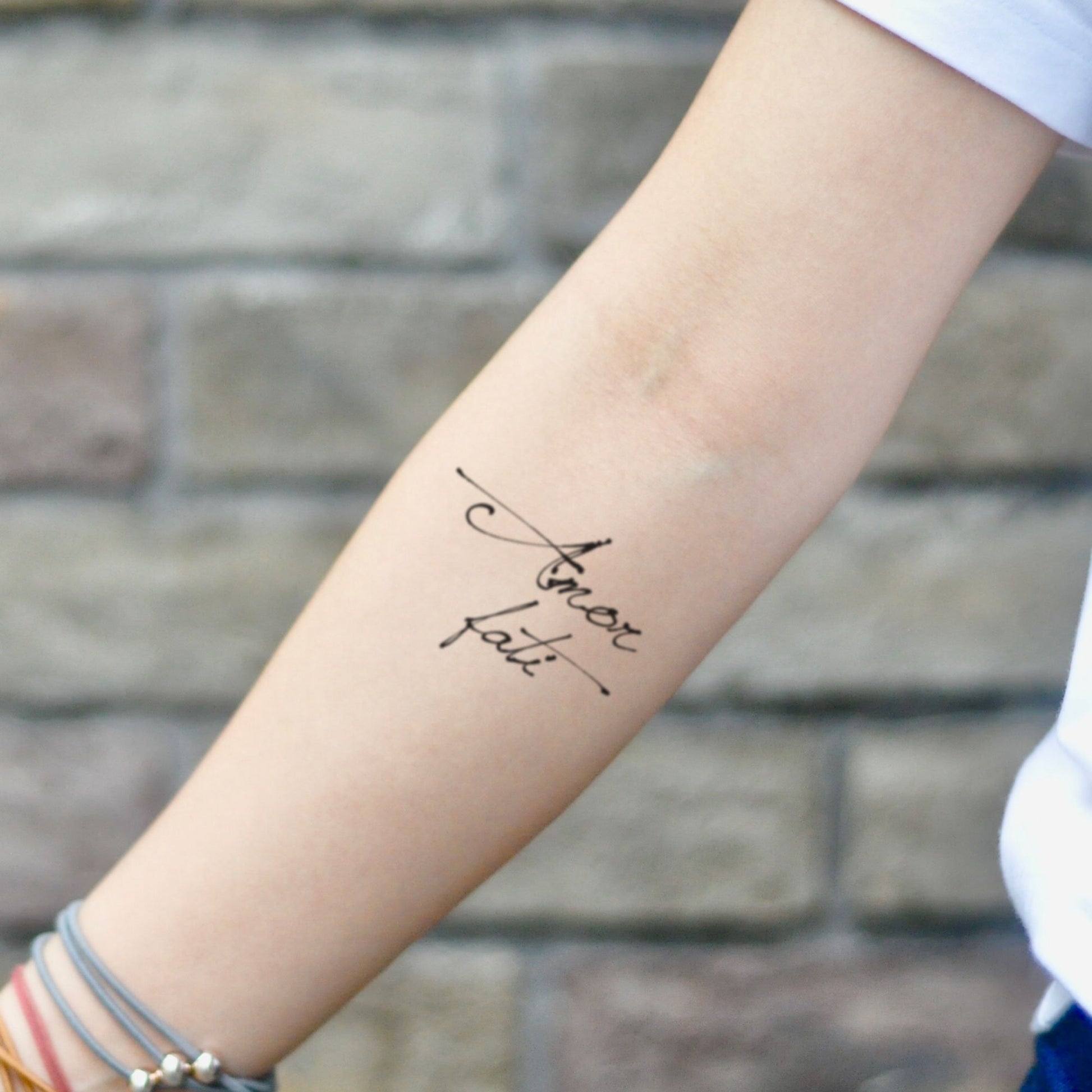 fake small amor fati lettering temporary tattoo sticker design idea on inner arm