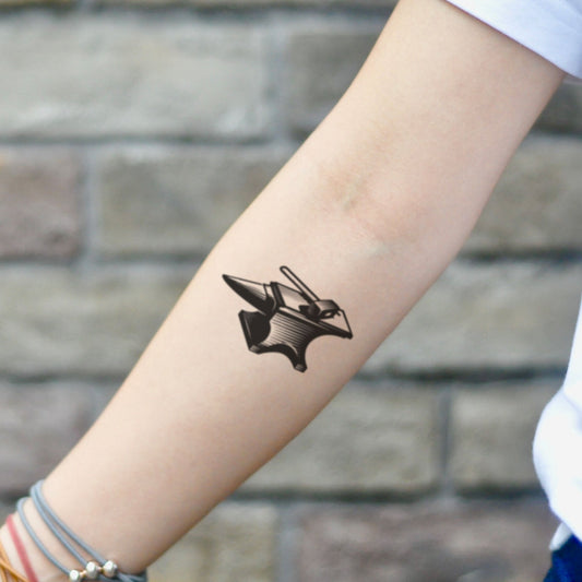 fake small anvil blacksmith illustrative temporary tattoo sticker design idea on inner arm