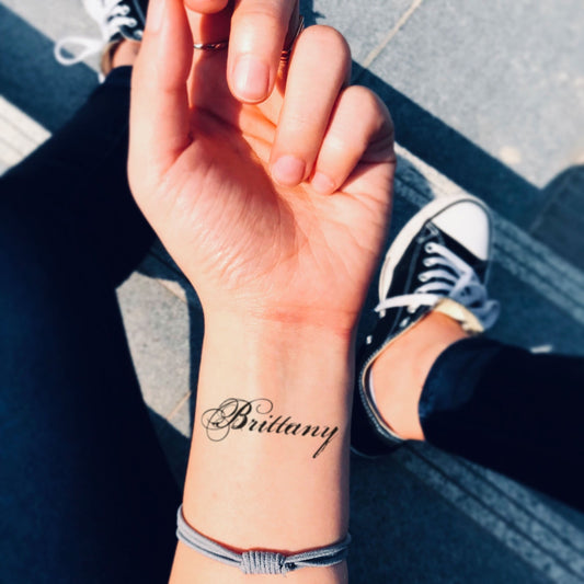 fake small brittany name lettering temporary tattoo sticker design idea on wrist