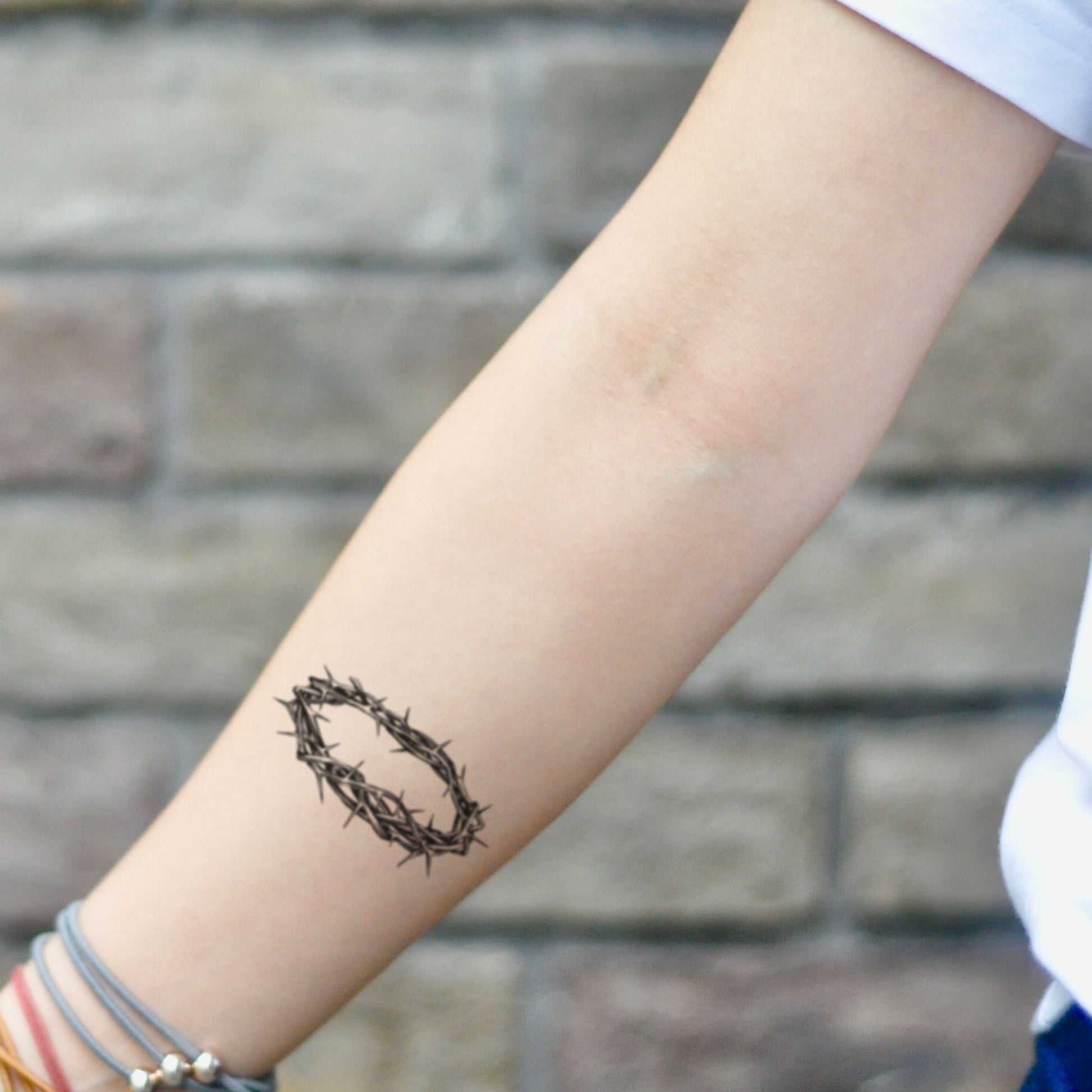 fake small crown of thorns Illustrative temporary tattoo sticker design idea on inner arm