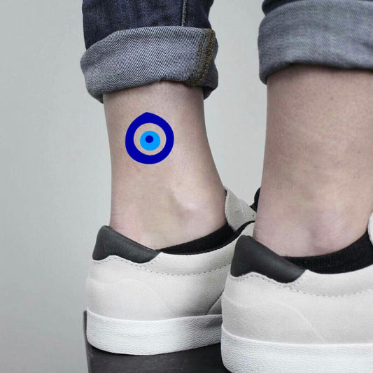 fake small evil eye mal de ojo dark delft nazar amulet light navy blue color temporary tattoo sticker design idea on ankle