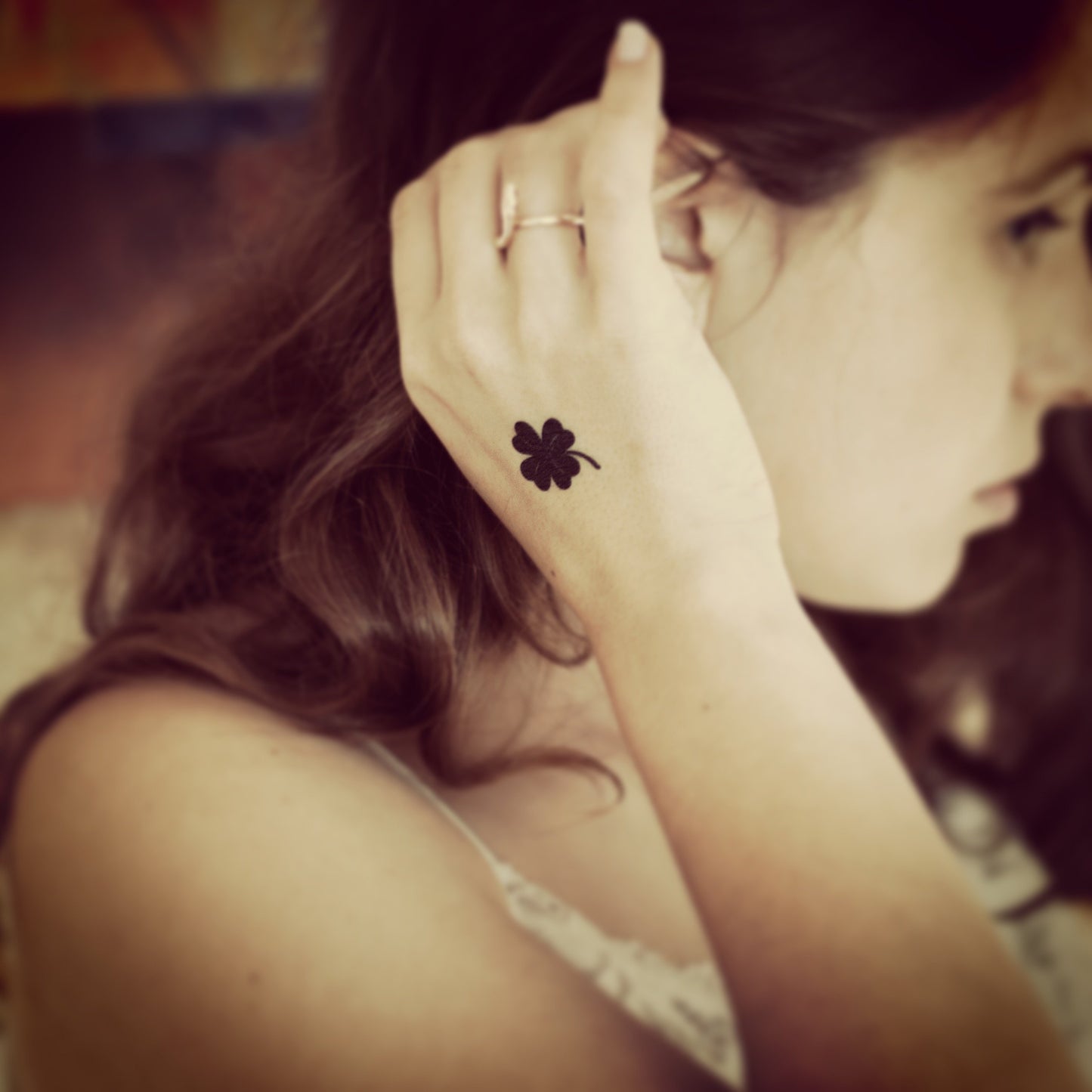 fake small black four leaf clover lucky charm shamrock minimalist temporary tattoo sticker design idea on wrist