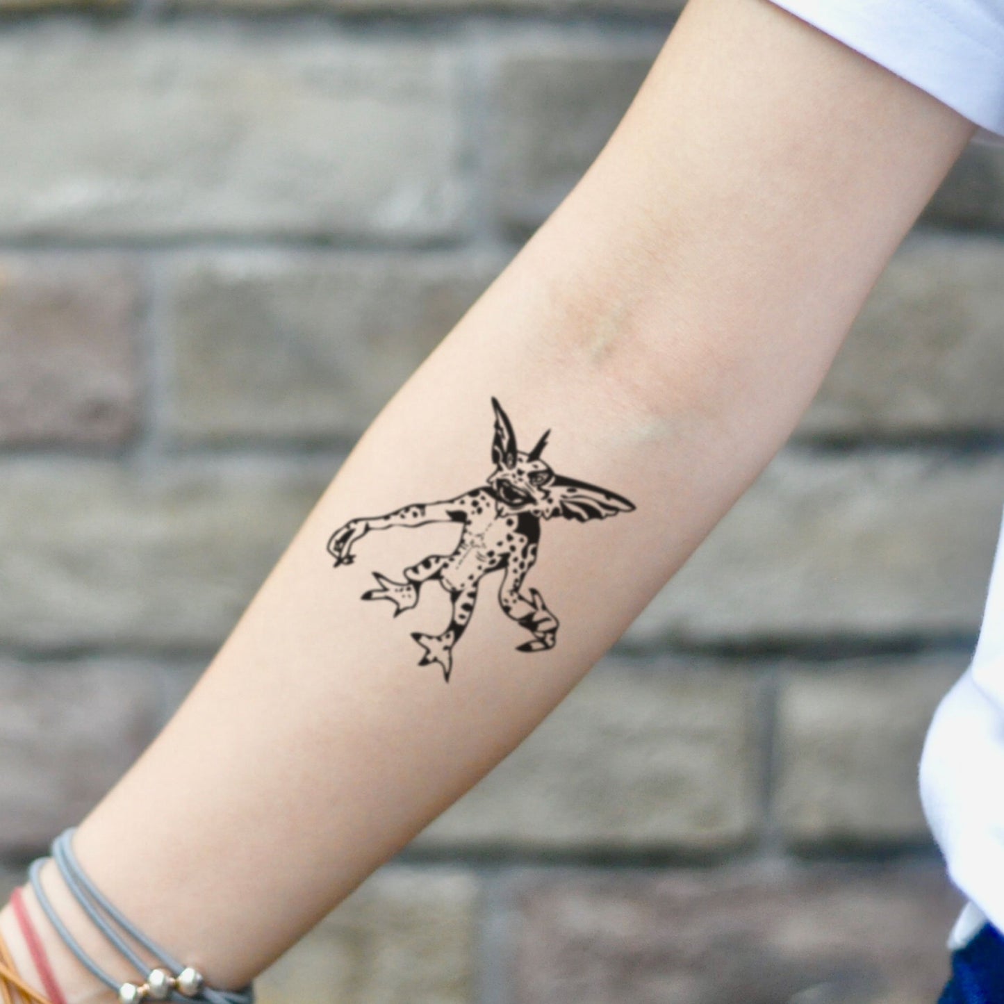 fake small gremlin illustrative temporary tattoo sticker design idea on inner arm