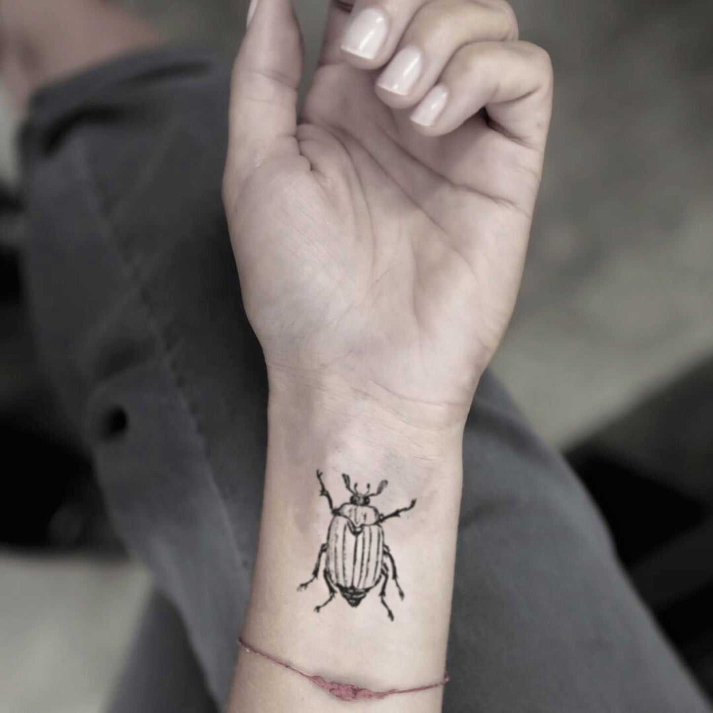 fake small june bug animal temporary tattoo sticker design idea on wrist