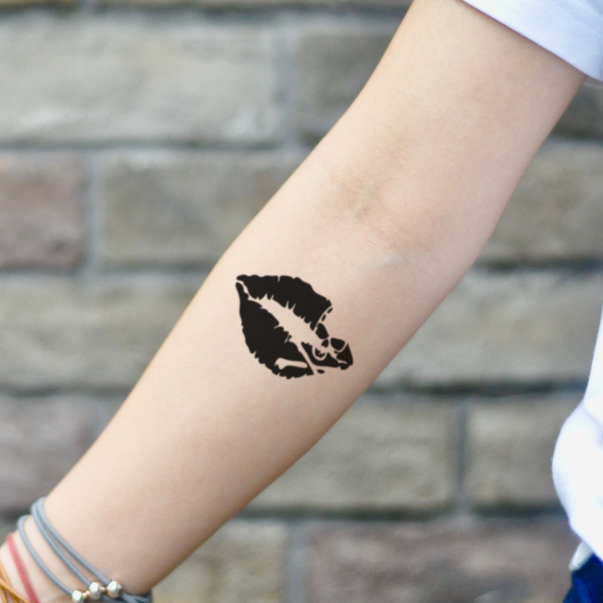 fake small kiss of death skull minimalist temporary tattoo sticker design idea on inner arm
