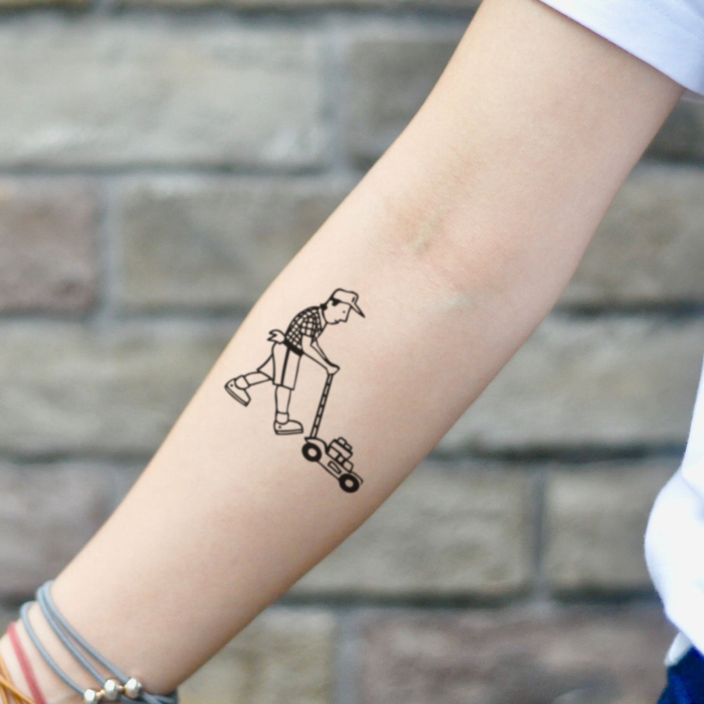 fake small lawn mower illustrative temporary tattoo sticker design idea on inner arm