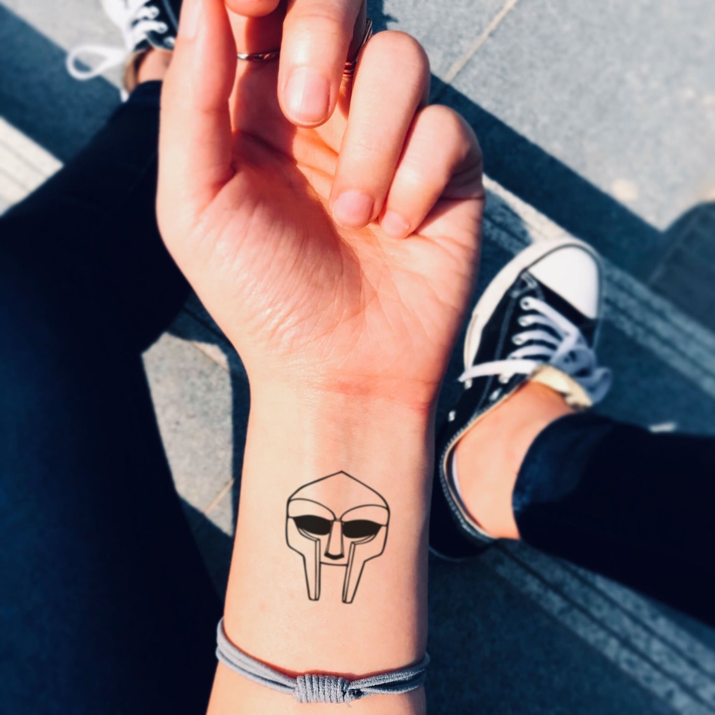 fake small mf doom mask millennial minimalist temporary tattoo sticker design idea on wrist