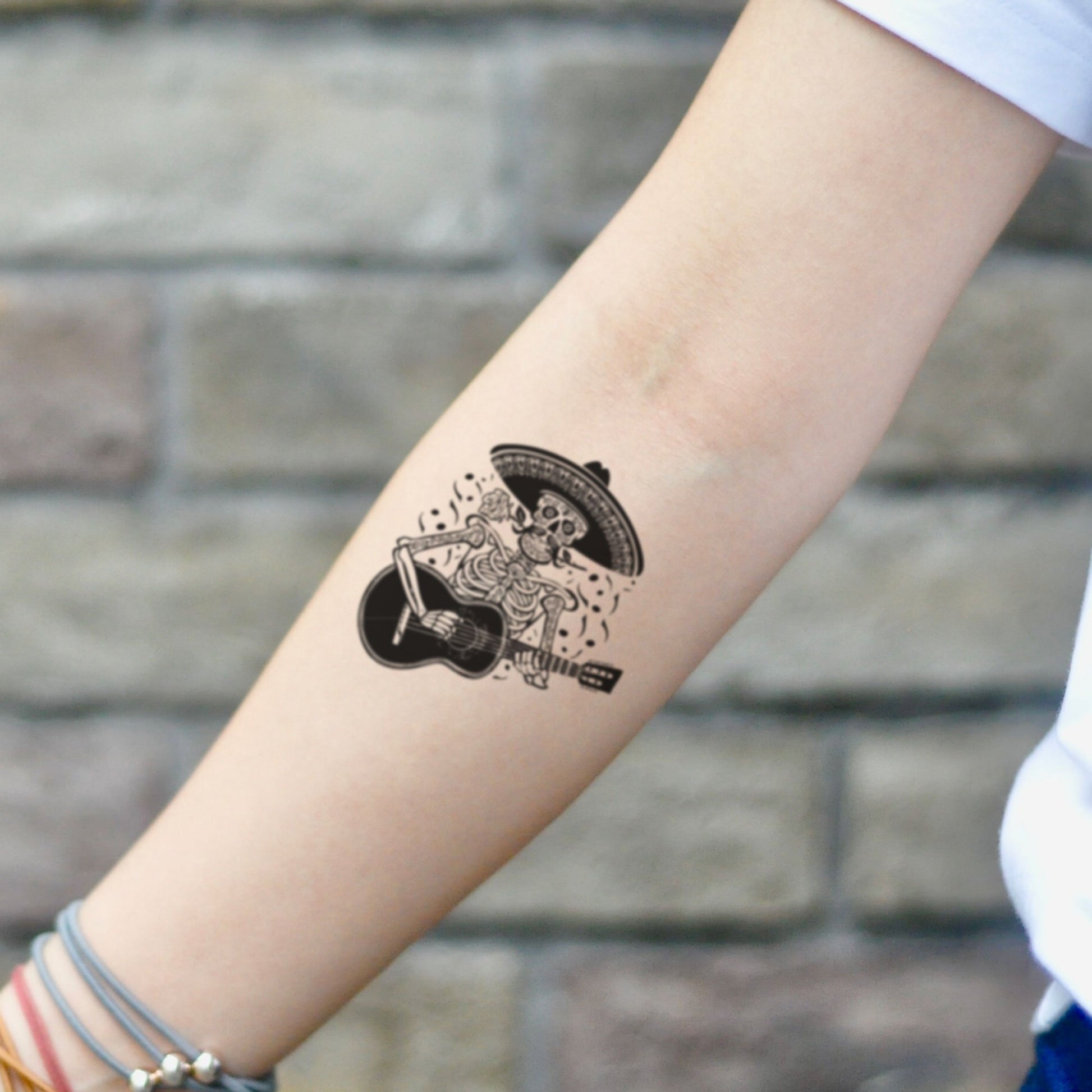 fake small mariachi skull music temporary tattoo sticker design idea on inner arm
