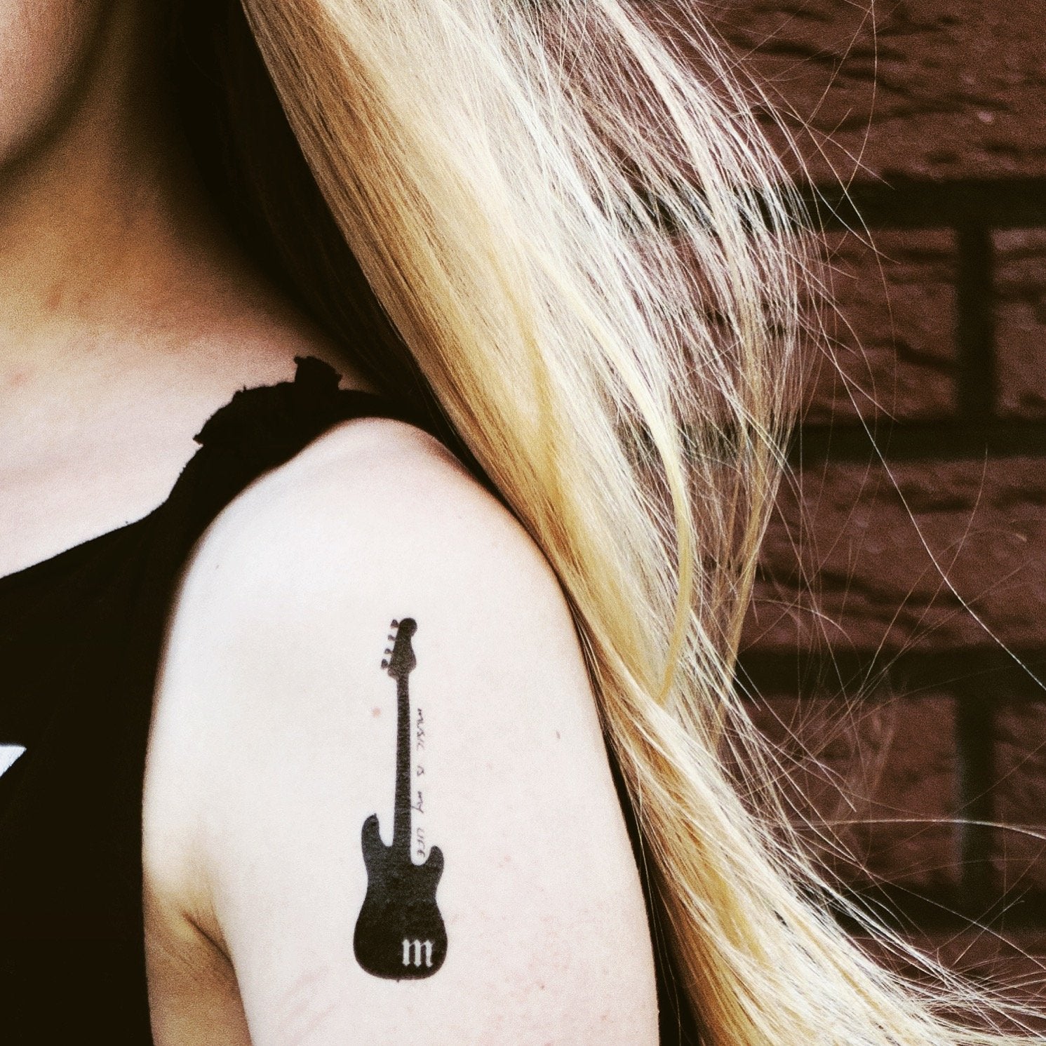 Crayon effect bass guitar tattoo located on the inner