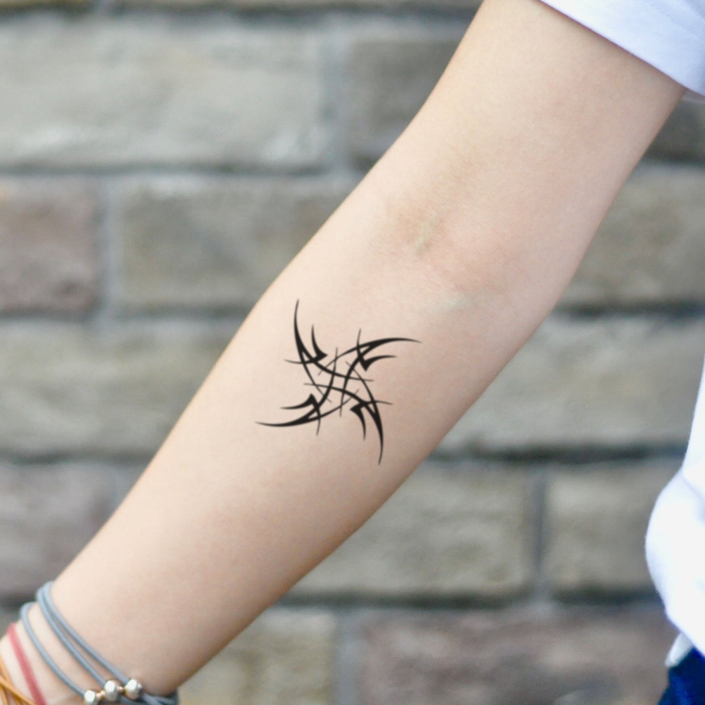 fake small ninja star pinwheel geometric temporary tattoo sticker design idea on inner arm