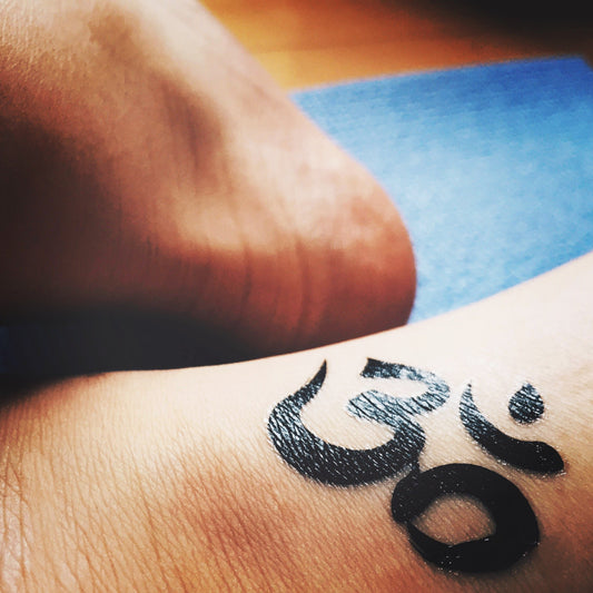 fake small om aum buddhist mantra symbol minimalist temporary tattoo sticker design idea on ankle