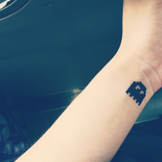 fake small pacman ghost minimalist temporary tattoo sticker design idea on wrist