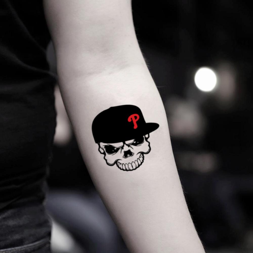 fake small phillies skull illustrative temporary tattoo sticker design idea on inner arm