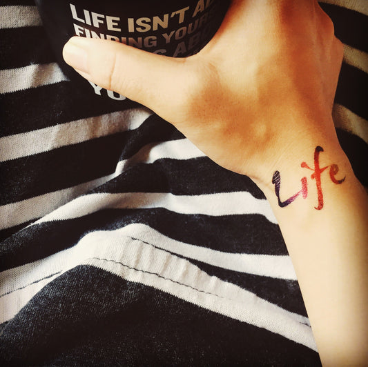 fake small rainbow life color lettering temporary tattoo sticker design idea on wrist