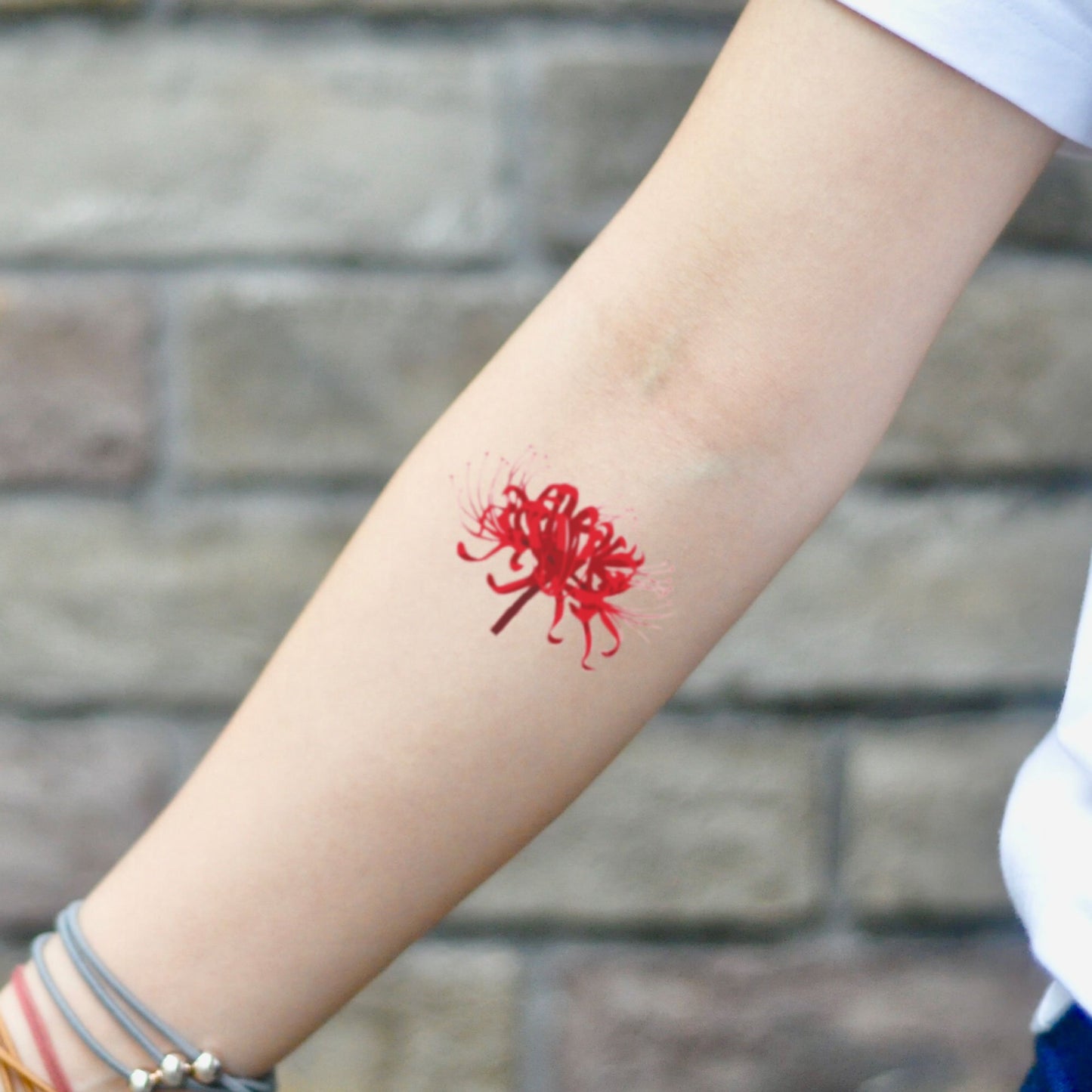 fake small red spider lily flower temporary tattoo sticker design idea on inner arm