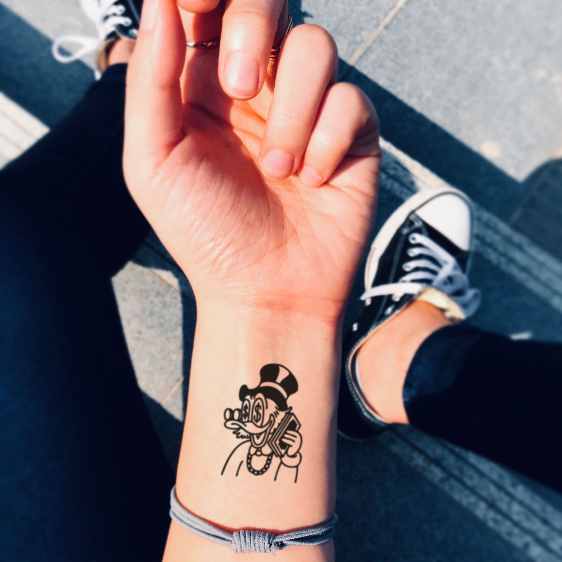 fake small scrooge mcduck drawing money donald duck cartoon temporary tattoo sticker design idea on wrist