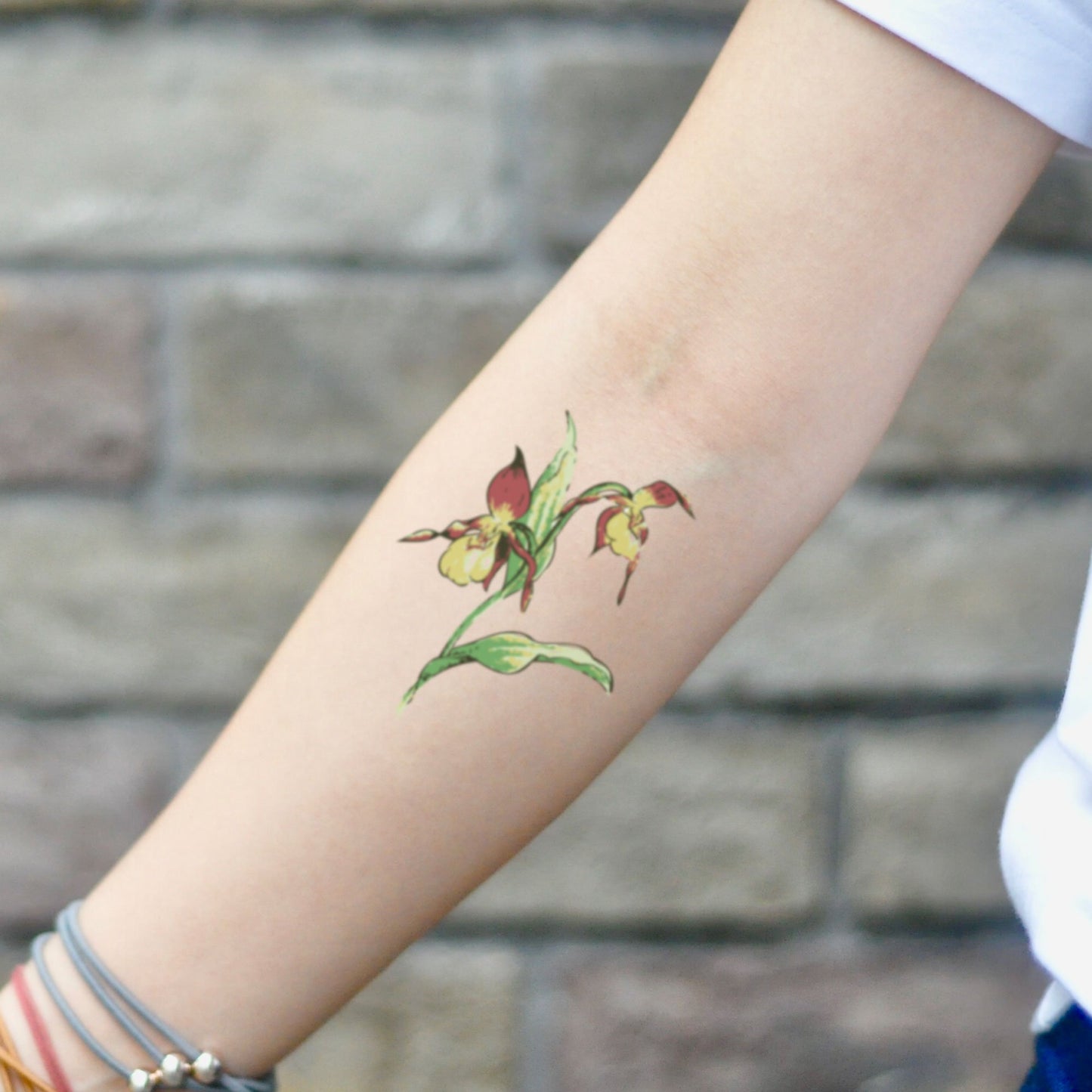 fake small showy lady slipper flower temporary tattoo sticker design idea on inner arm
