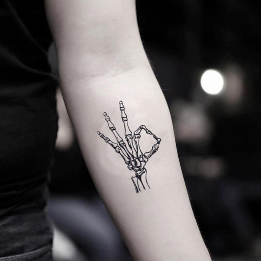 fake small skeleton hand bone fingers illustrative temporary tattoo sticker design idea on inner arm