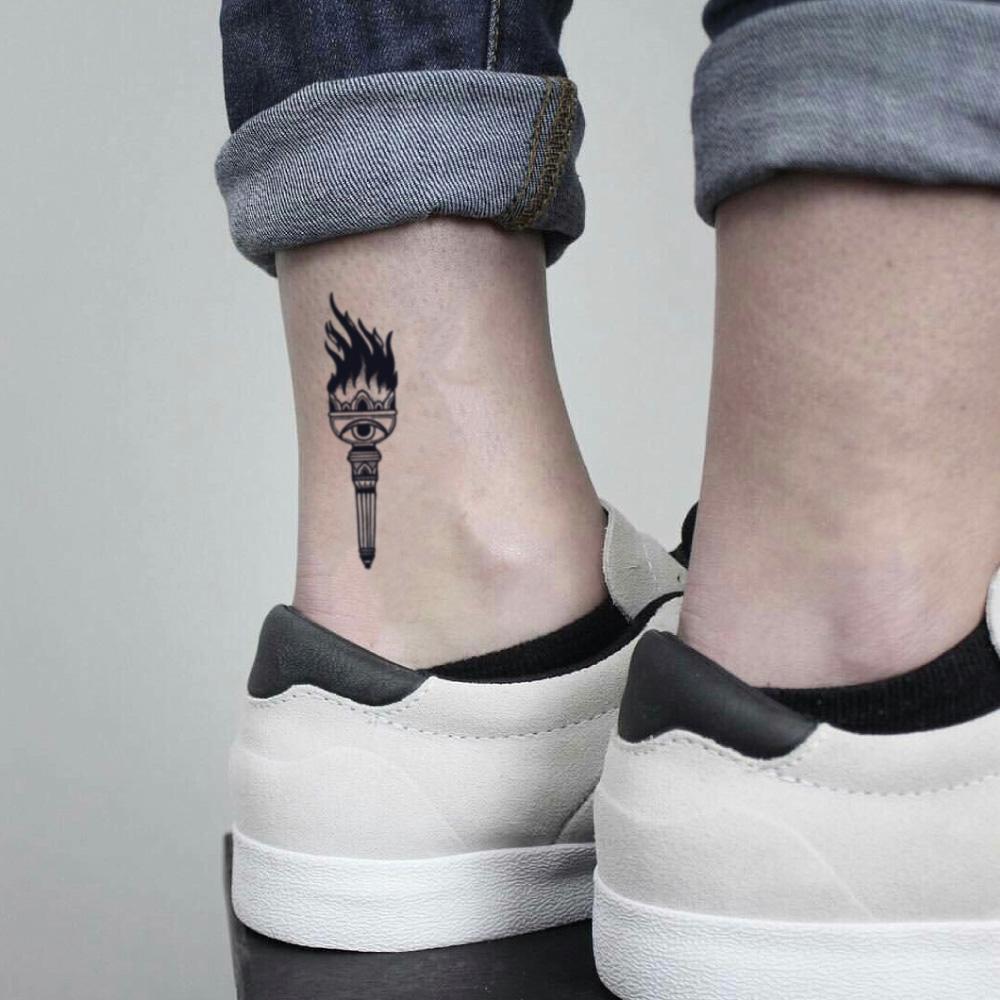fake small torch illustrative temporary tattoo sticker design idea on ankle