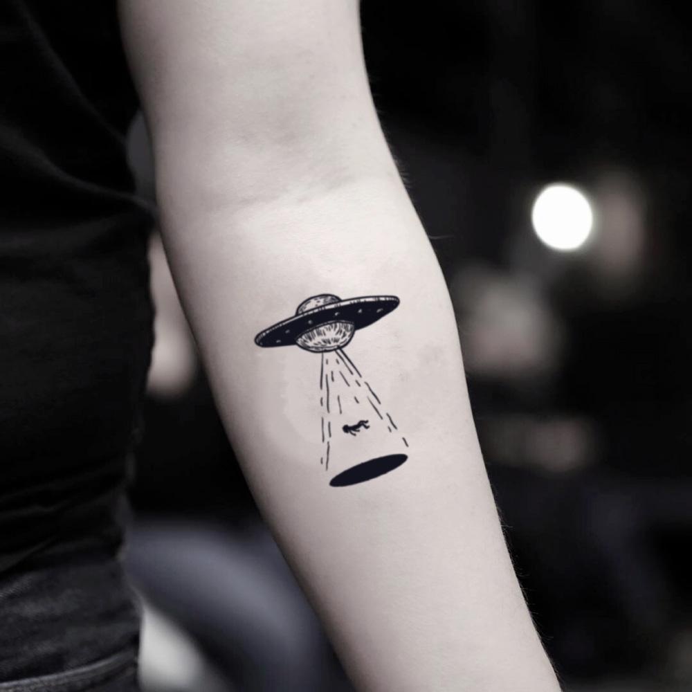 fake small ufo flying saucer illustrative temporary tattoo sticker design idea on inner arm