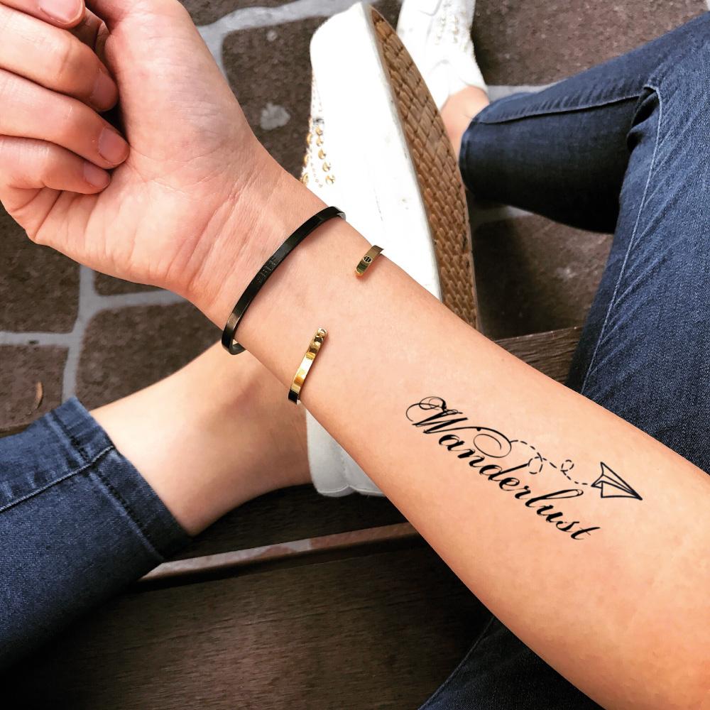 fake small wanderlust quote lettering temporary tattoo sticker design idea on forearm