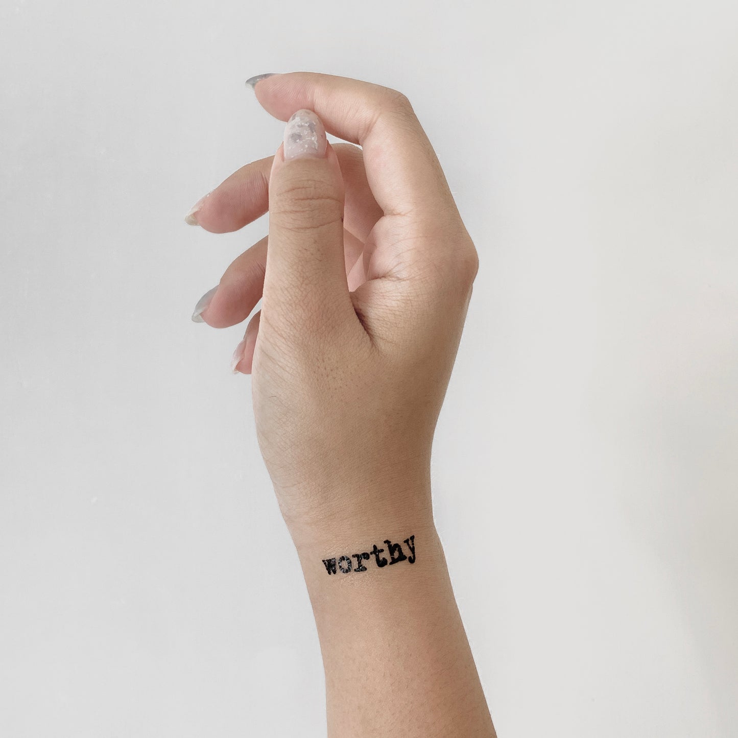 fake small worthy worth it lettering temporary tattoo sticker design idea on wrist