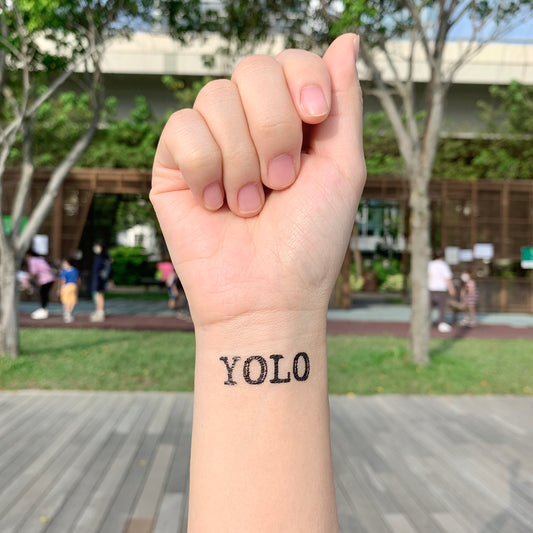 fake small yolo lettering temporary tattoo sticker design idea on wrist