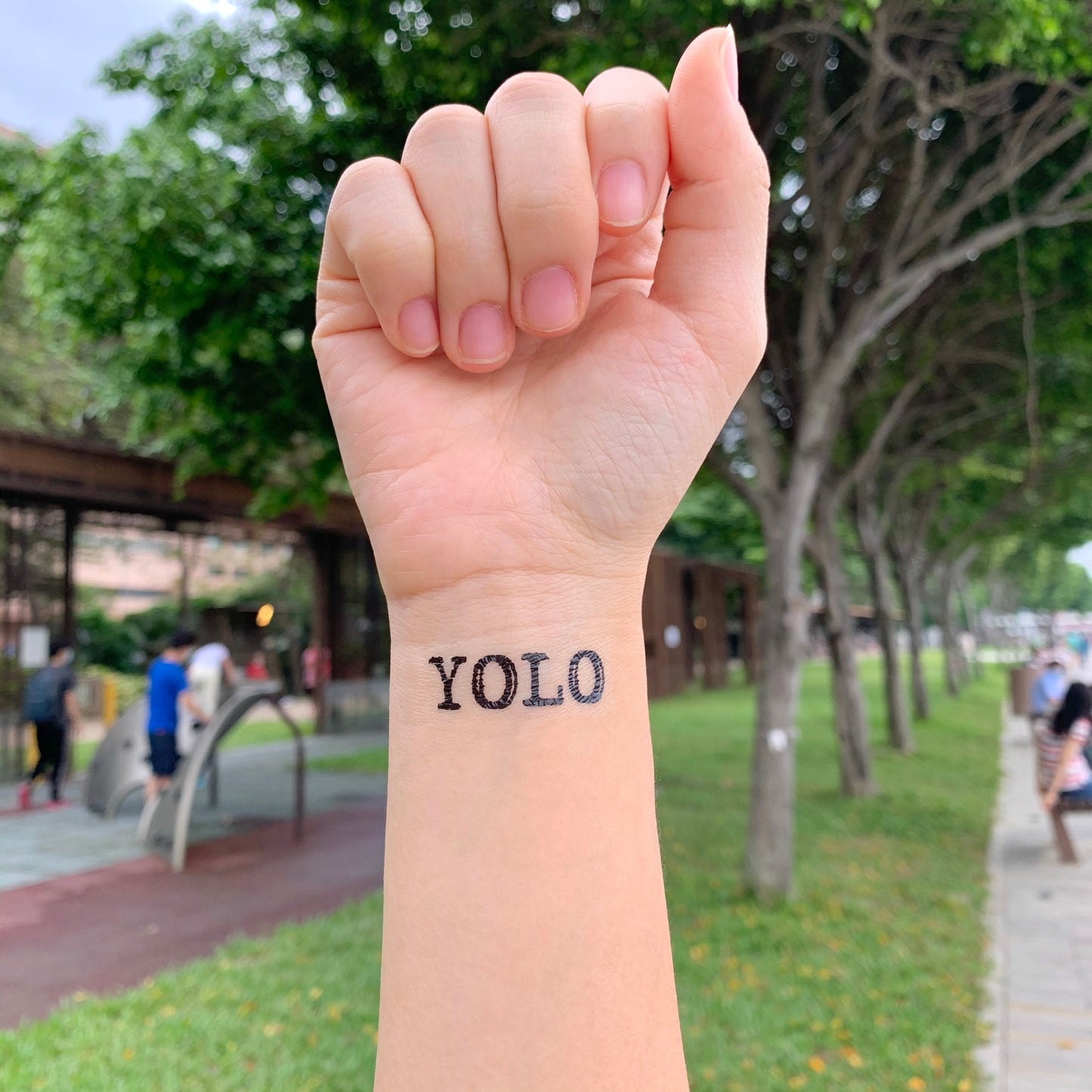 fake small yolo lettering temporary tattoo sticker design idea on wrist